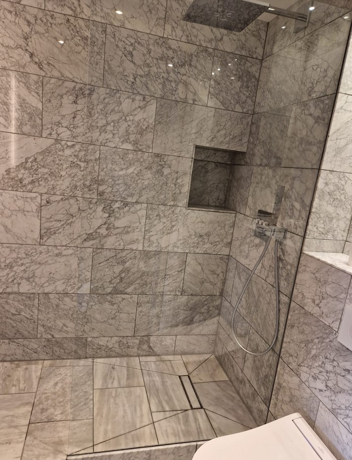 Grey marble walk-in shower by AG Signature Renovation